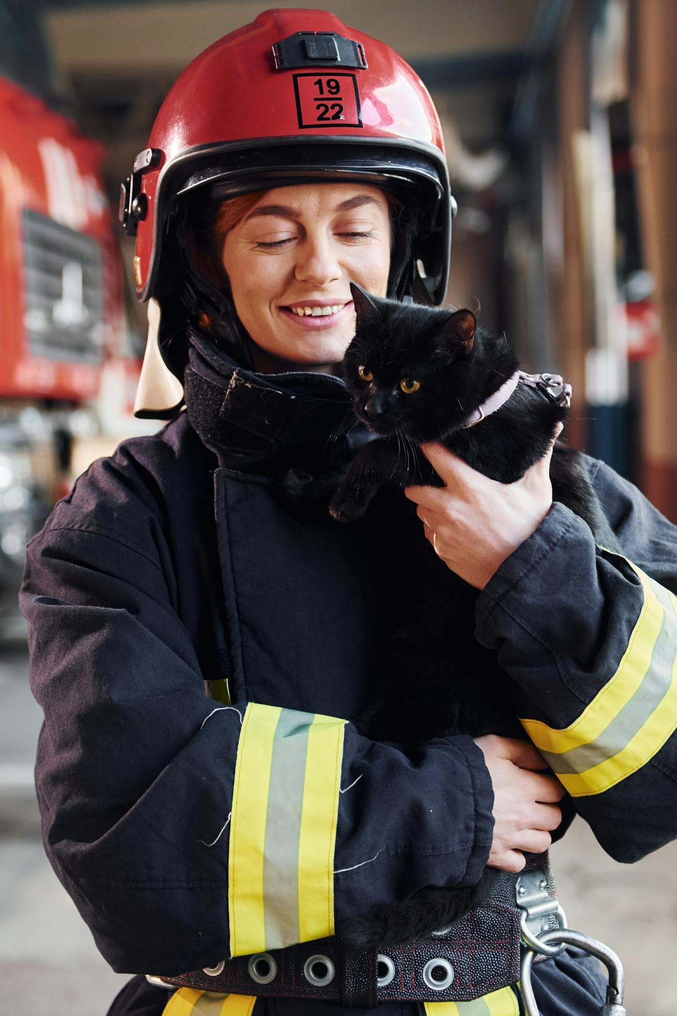 female-fire-fighter-holding-black-cat-demonstrating-pet-fire-safety-tips