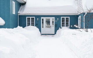 house-with-snow-covering-roof-winter-water-damage-prevention