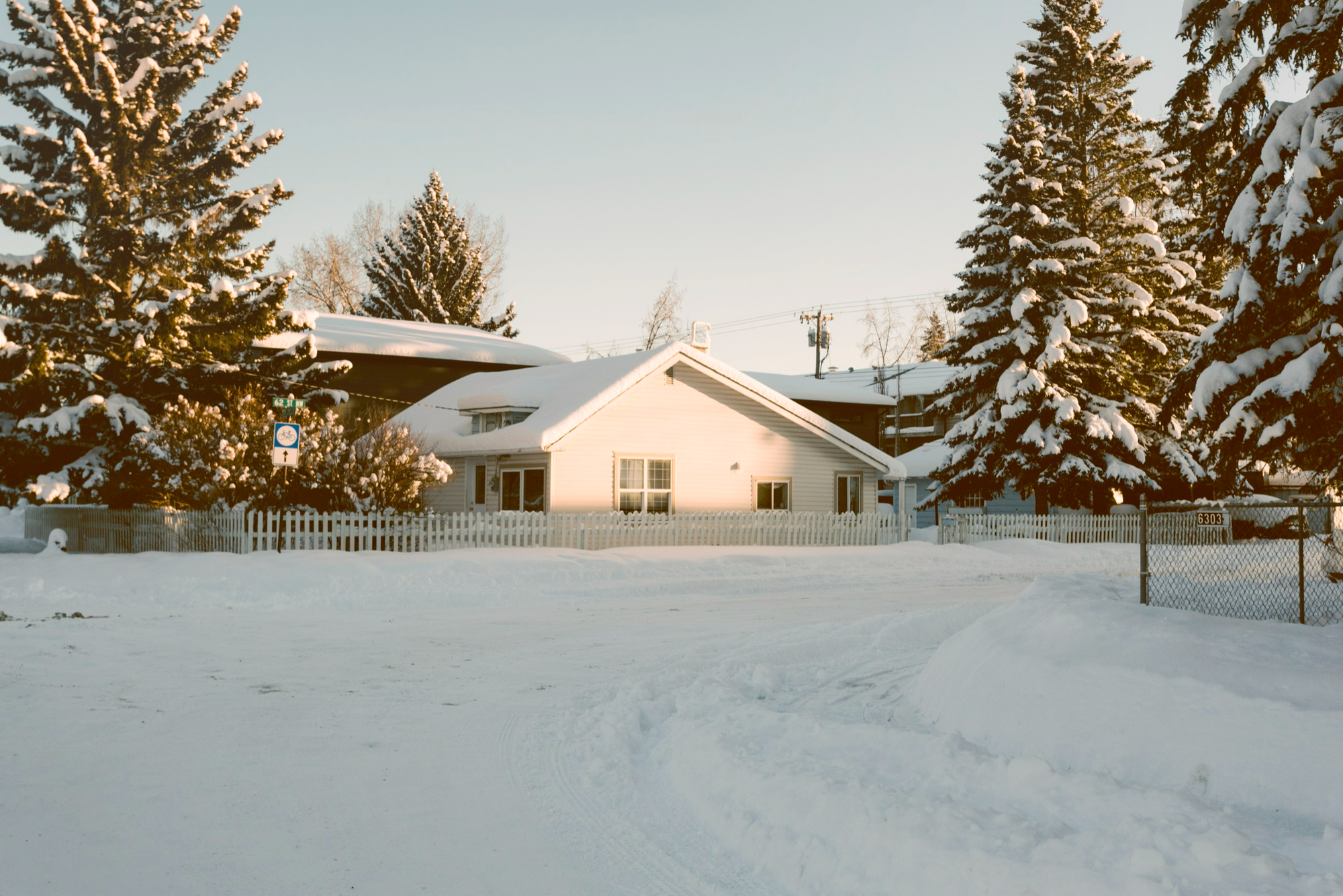 house-with-snowy-pine-trees-winter-beginning-to-melt-and-experience-spring-thaw-and protecting-your-home-from-water-damage