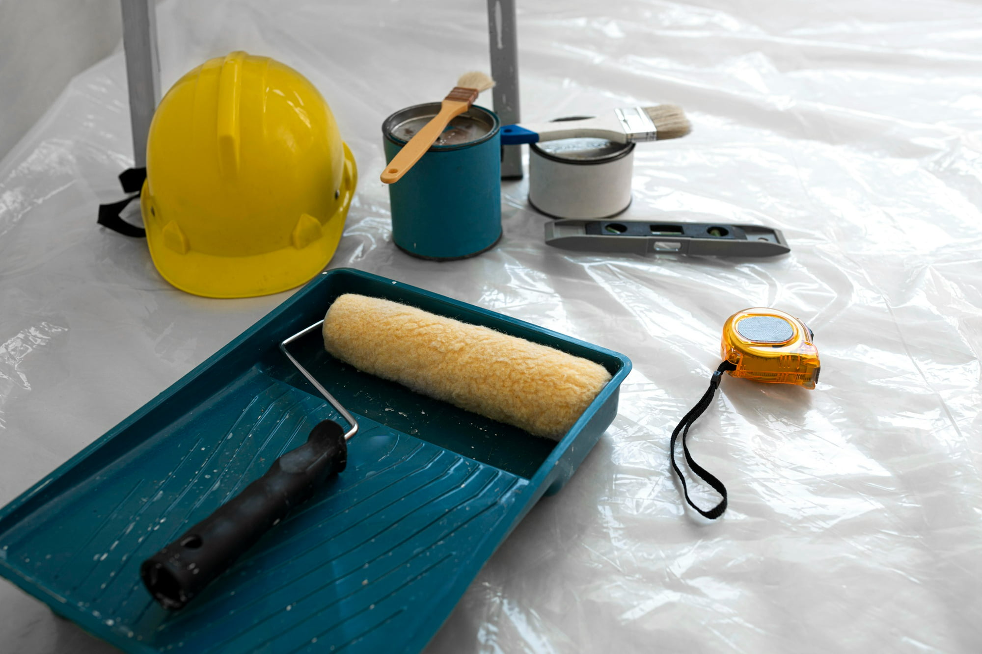 paint-supplies-on-plastic-sheet-on-floor-abiding-by-tips-for-preventing-fire-damage-during-home-renovation